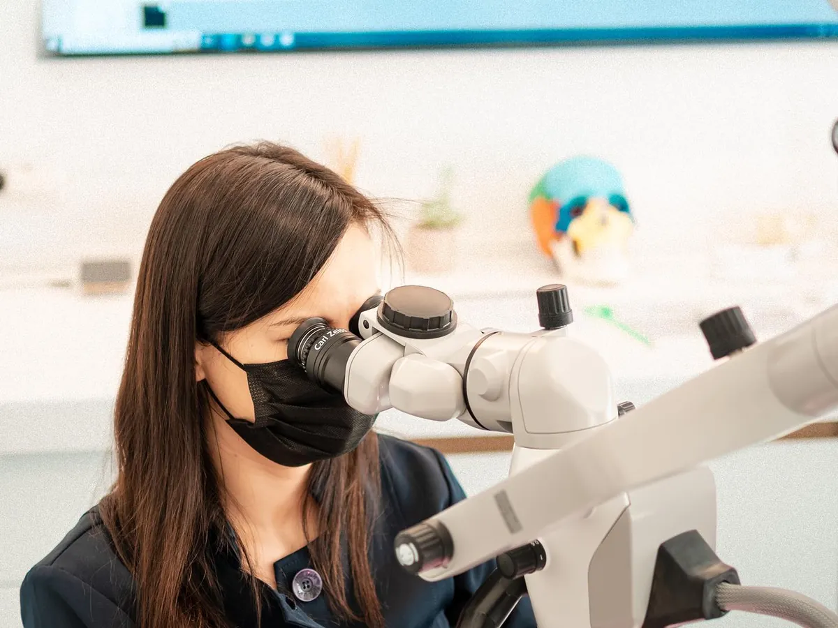 Medic D'Institute lucrând la microscopul dentar