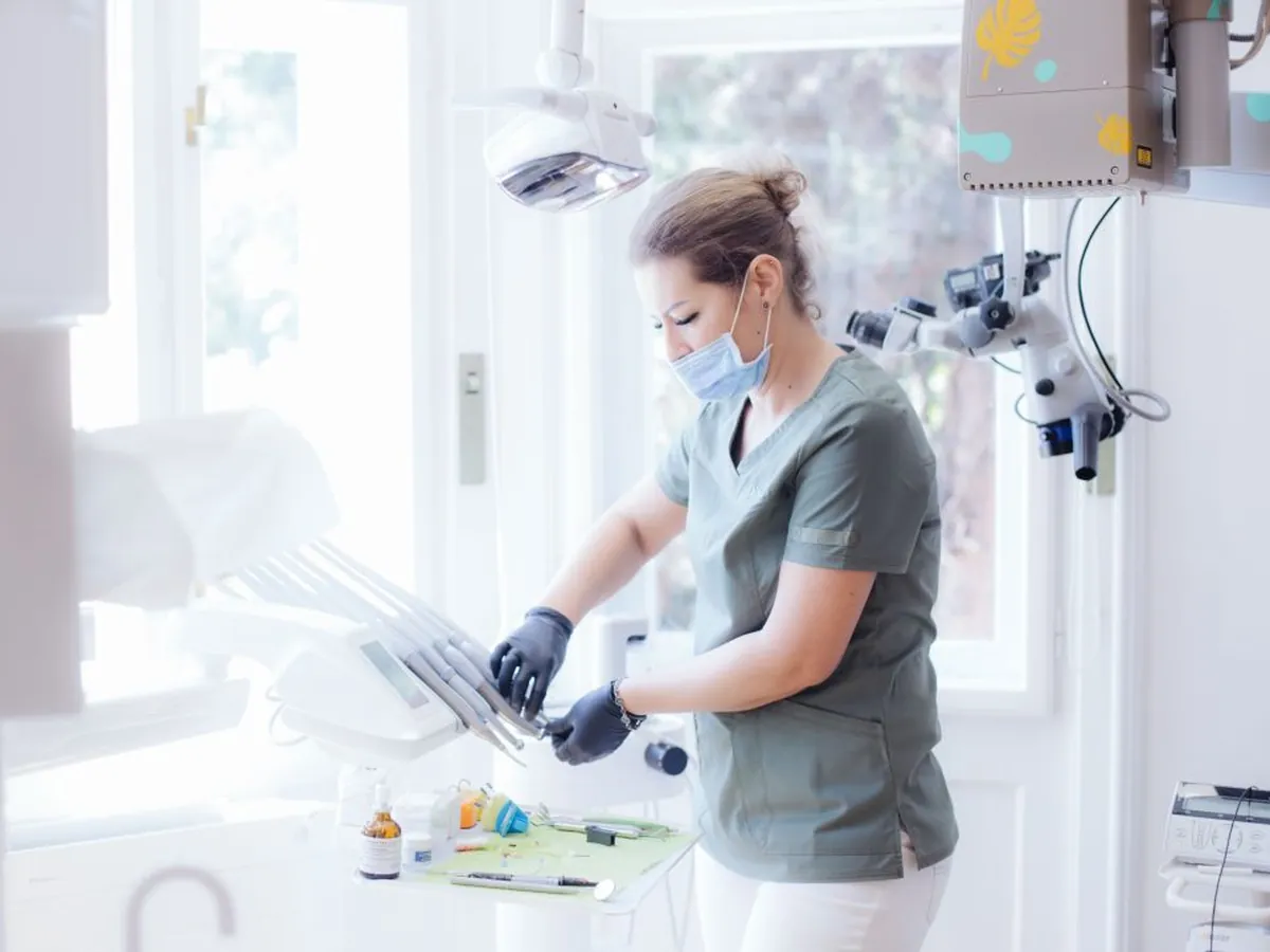 Asistentă D'Institute pregătind instrumentele la unitul stomatologic